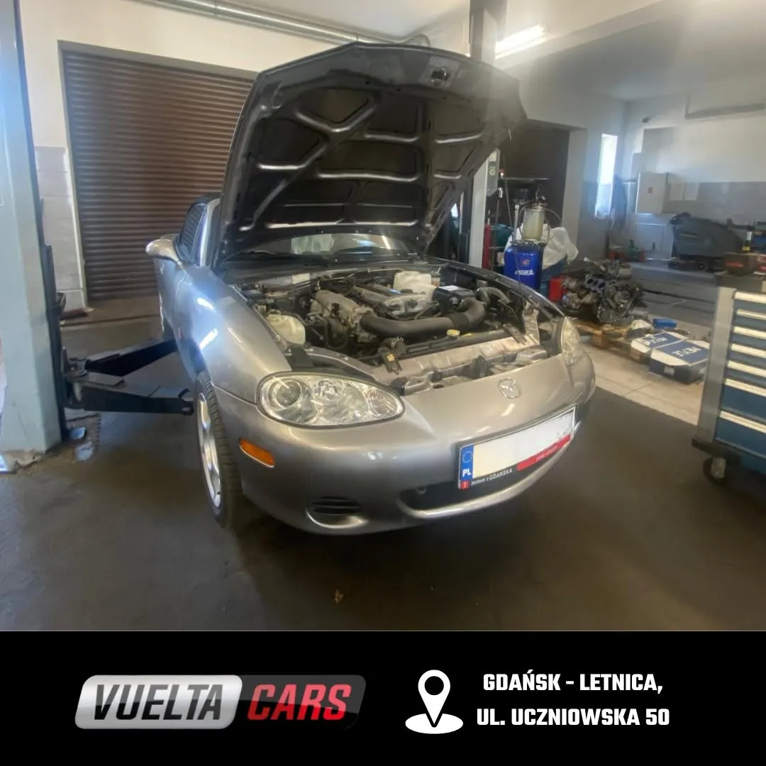 Szara Mazda z otwartą maską w hali Vuelta Cars